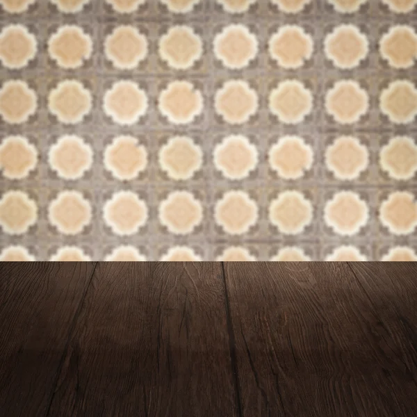 Wood table top and blur vintage ceramic tile pattern wall — Stock Photo, Image