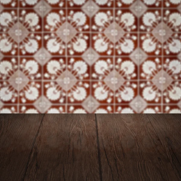 Wood table top and blur vintage ceramic tile pattern wall — Stock Photo, Image