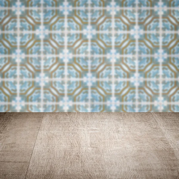 Wood table top and blur vintage ceramic tile pattern wall — Stock Photo, Image