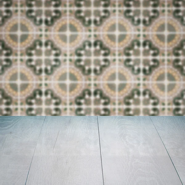 Wood table top and blur vintage ceramic tile pattern wall — Stock Photo, Image