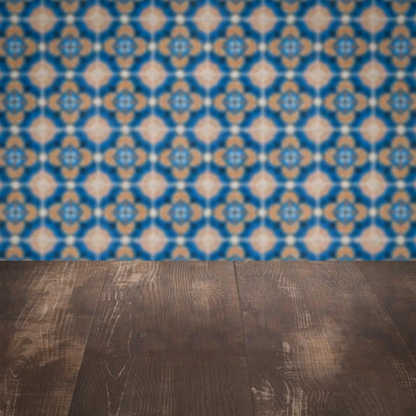 Wood table top and blur vintage ceramic tile pattern wall — Stock Photo, Image