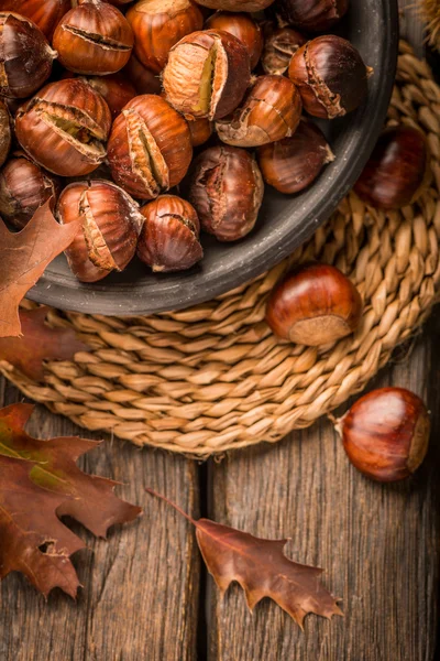 Roasted chestnuts and leaves — Stock Photo, Image