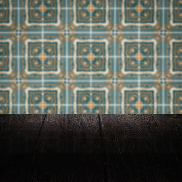 Wood table top and blur vintage ceramic tile pattern wall — Stock Photo, Image