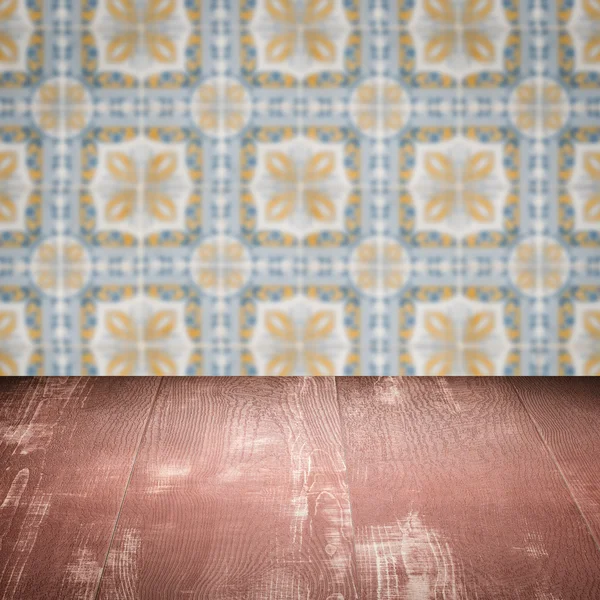 Wood table top and blur vintage ceramic tile pattern wall — Stock Photo, Image