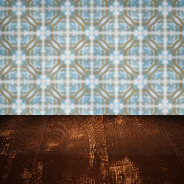 Wood table top and blur vintage ceramic tile pattern wall — Stock Photo, Image