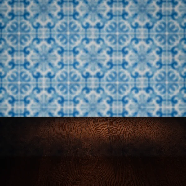 Wood table top and blur vintage ceramic tile pattern wall — Stock Photo, Image