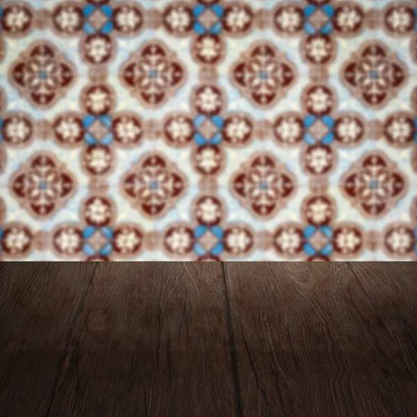 Wood table top and blur vintage ceramic tile pattern wall — Stock Photo, Image