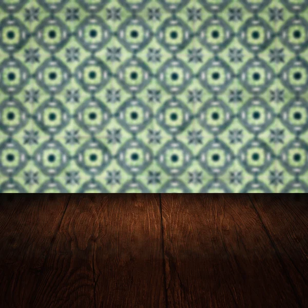 Wood table top and blur vintage ceramic tile pattern wall — Stock Photo, Image