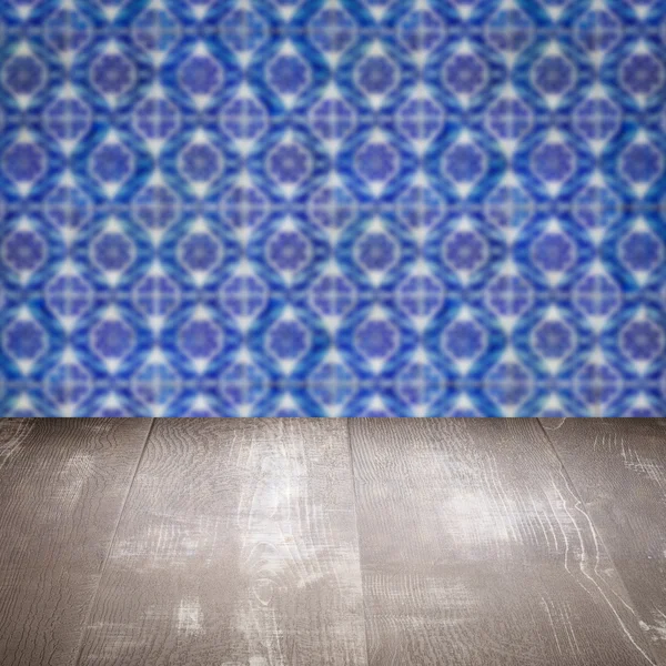 Wood table top and blur vintage ceramic tile pattern wall — Stock Photo, Image