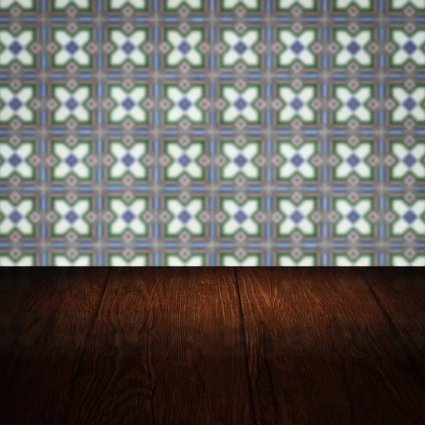 Wood table top and blur vintage ceramic tile pattern wall — Stock Photo, Image