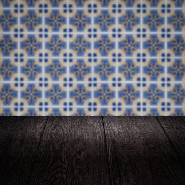 Wood table top and blur vintage ceramic tile pattern wall — Stock Photo, Image