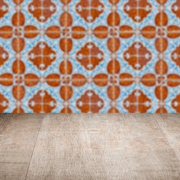 Wood table top and blur vintage ceramic tile pattern wall — Stock Photo, Image