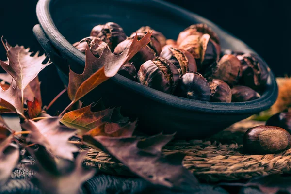 Geröstete Kastanien und Blätter — Stockfoto