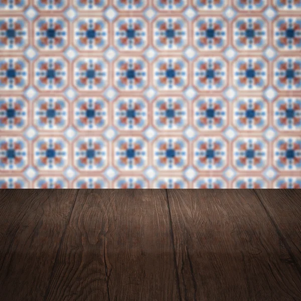 Wood table top and blur vintage ceramic tile pattern wall — Stock Photo, Image