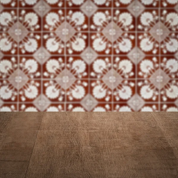 Wood table top and blur vintage ceramic tile pattern wall — Stock Photo, Image