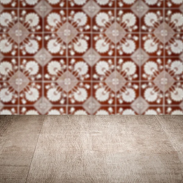 Wood table top and blur vintage ceramic tile pattern wall — Stock Photo, Image