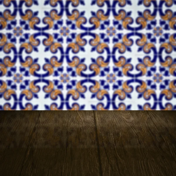 Wood table top and blur vintage ceramic tile pattern wall — Stock Photo, Image