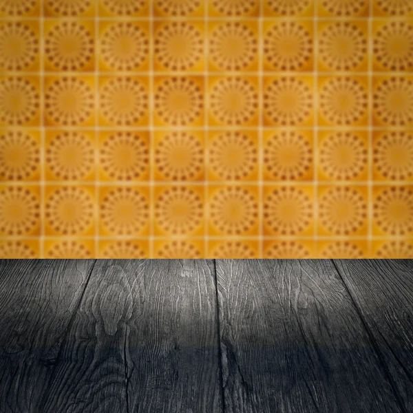 Wood table top and blur vintage ceramic tile pattern wall — Stock Photo, Image