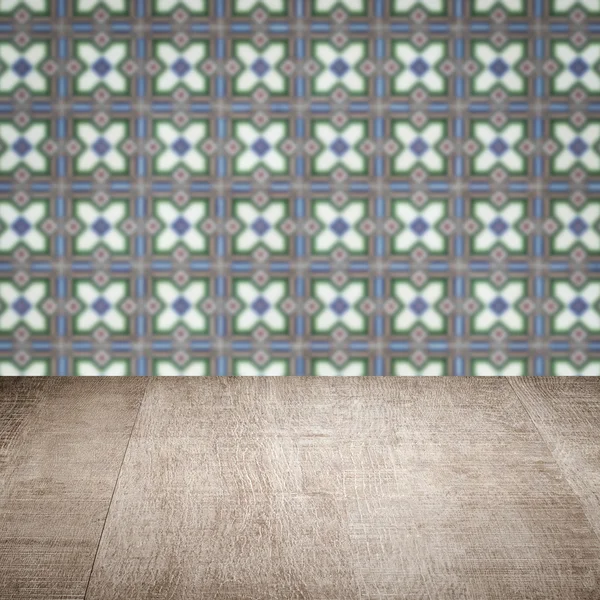 Wood table top and blur vintage ceramic tile pattern wall — Stock Photo, Image