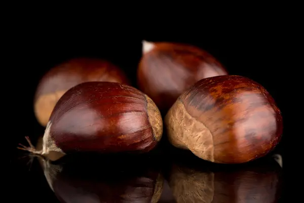 Castanhas em um fundo reflexivo preto — Fotografia de Stock