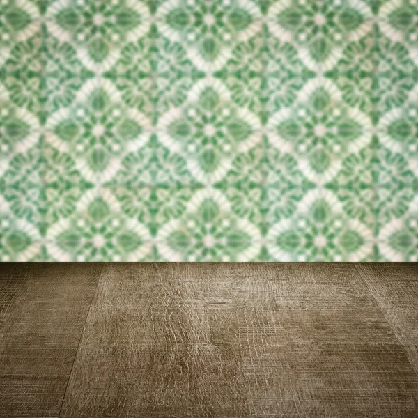 Wood table top and blur vintage ceramic tile pattern wall — Stock Photo, Image