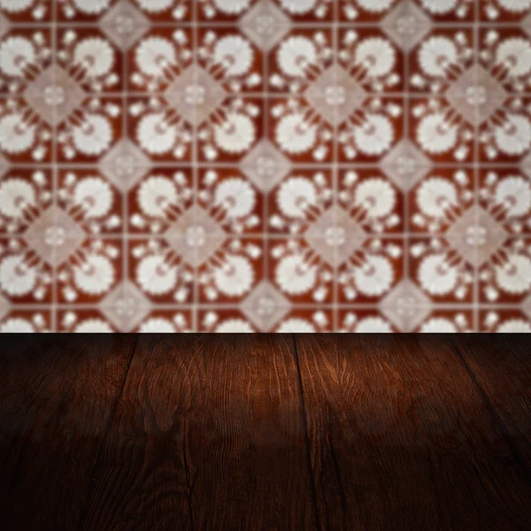 Wood table top and blur vintage ceramic tile pattern wall — Stock Photo, Image