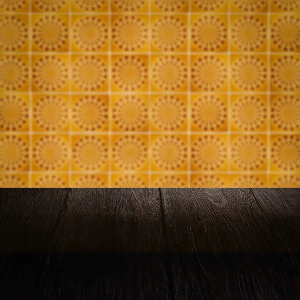 Wood table top and blur vintage ceramic tile pattern wall — Stock Photo, Image