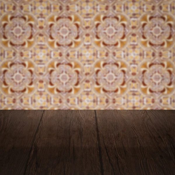 Wood table top and blur vintage ceramic tile pattern wall — Stock Photo, Image