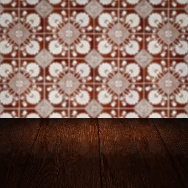 Wood table top and blur vintage ceramic tile pattern wall — Stock Photo, Image