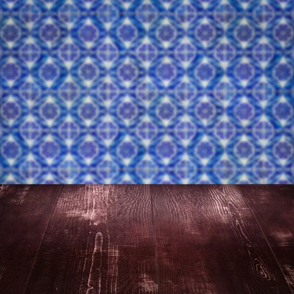 Wood table top and blur vintage ceramic tile pattern wall — Stock Photo, Image