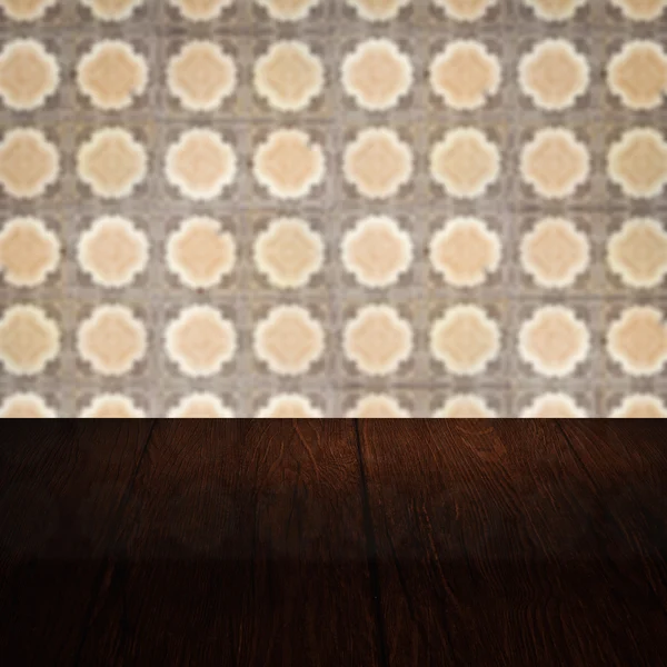 Wood table top and blur vintage ceramic tile pattern wall — Stock Photo, Image