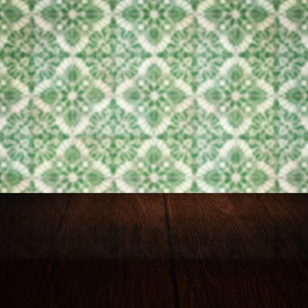 Wood table top and blur vintage ceramic tile pattern wall — Stock Photo, Image