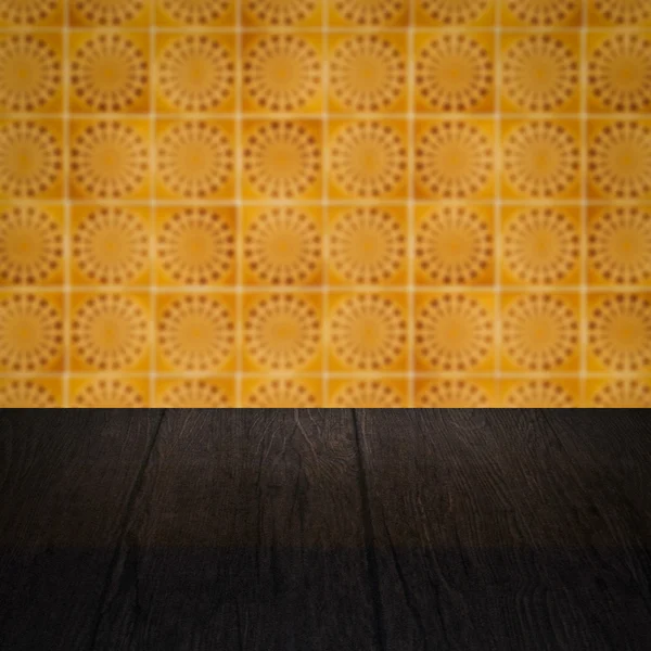 Wood table top and blur vintage ceramic tile pattern wall — Stock Photo, Image