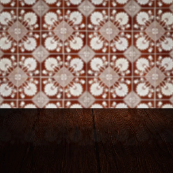 Wood table top and blur vintage ceramic tile pattern wall Stock Image