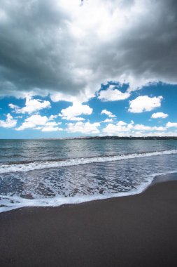 Porto Riko 'dan görünen kıyılardaki güzel siyah kumsal ve okyanus üzerinde fırtına bulutları
