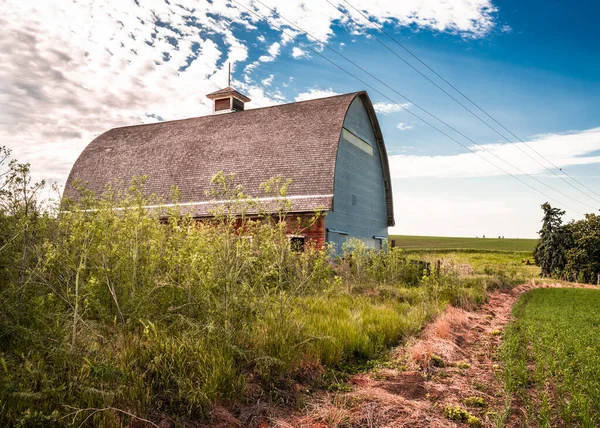 田舎の農場風景の中に放棄された古い木製の赤い納屋 — ストック写真