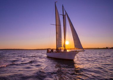 Newport, Rhode Island - 29 Temmuz 2020 Newport Rhode Island kıyıları boyunca renkli bir günbatımı gökyüzü altında yelken açar.