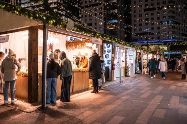 Boston, Massachusetts - 5 Aralık 2025: Boston 'daki Liaport bölgesinden gece görülen tatil Noel pazarının görüntüsü.