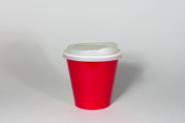 Kafe kültürünün, geri dönüşümün bir sembolü olarak beyaz arka planda izole edilmiş kırmızı bir kahve fincanı. ürün ambalajlama ve atık.