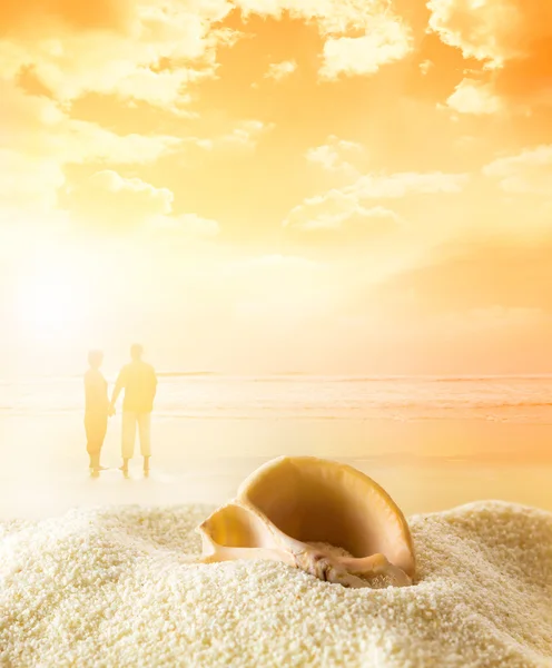 Couple on the beach at sunset — Stock Photo, Image