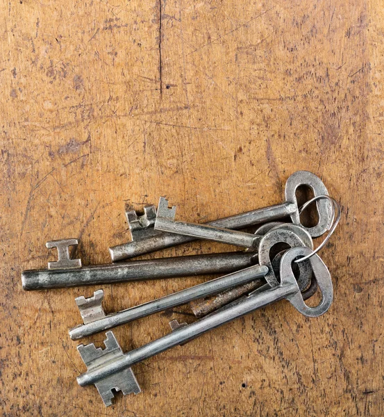 Bunch of big antique keys on wooden table — Stock Photo, Image