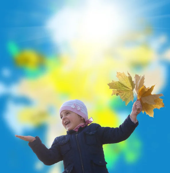 Glückliches kleines Mädchen mit einem Strauß herbstlicher gelber trockener Blätter — Stockfoto