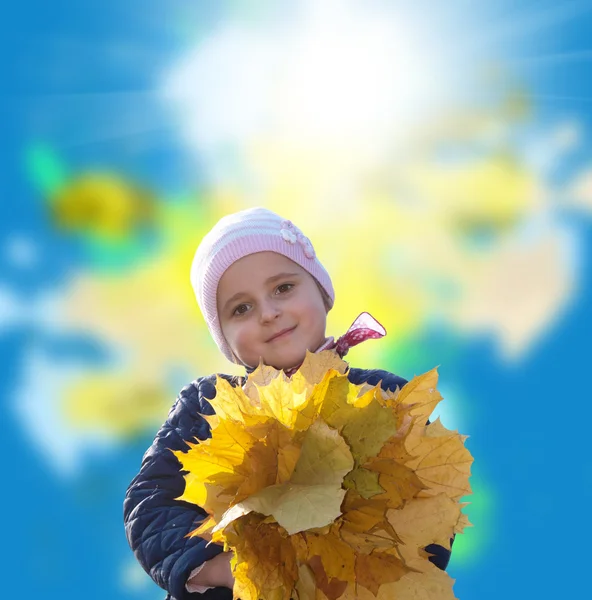 Glückliches kleines Mädchen mit einem Strauß herbstlicher gelber trockener Blätter — Stockfoto