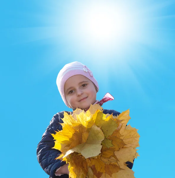 Glückliches kleines Mädchen mit einem Strauß herbstlicher gelber trockener Blätter — Stockfoto