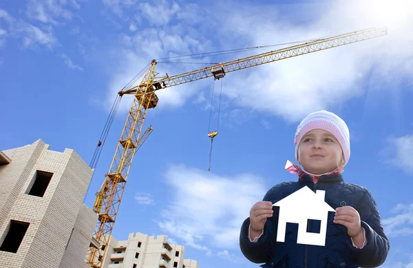 Щаслива дівчинка з паперовим будинком в руках. Будівництво — стокове фото