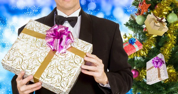 Män i smoking och julafton träd med gåvor — Stockfoto