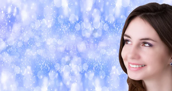 Beauty, people and health concept - beautiful young Women face over blue Christmas background — Stock Photo, Image