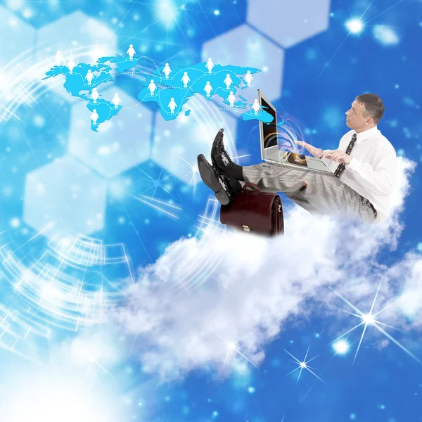 Бизнесмен на облаках с ноутбуком — стоковое фото