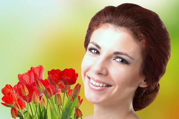 美丽的花束新鲜红色郁金香的美丽女人 — 图库照片