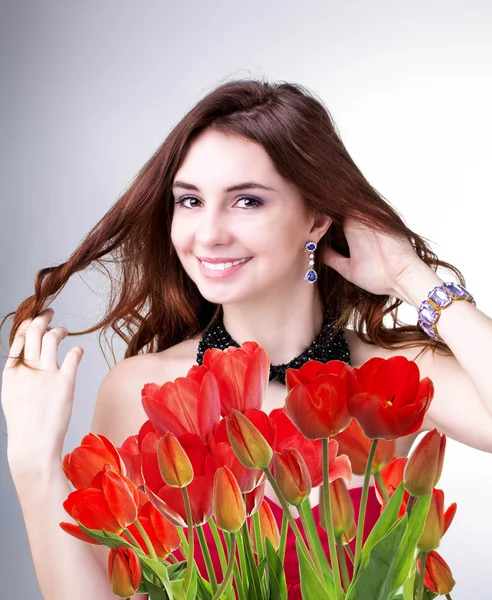 Krása ženy s krásná kytice čerstvé červené tulipány — Stock fotografie